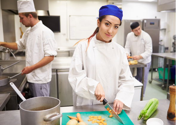 Chefs work at different kitchen stations to prepare a meal